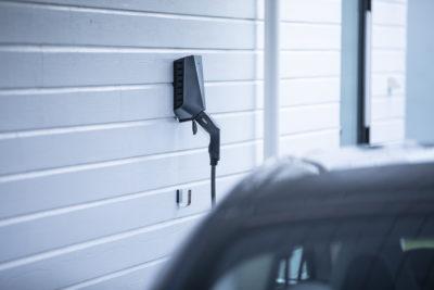 Easee Home Wallbox an Hauswand hinter einem Elektroauto