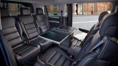 Hinterer Innenraum des Elektro-Vans Fiat E-Ulysse mit 5 Sitzen in Konfrenzbestuhlung und einem Tisch in der Mitte