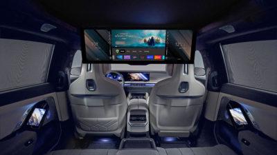 Innenraum des gepanzerten BMW i7 mit abgedunkelten Hintersitzen und großem Bildschirm in der Mitte
